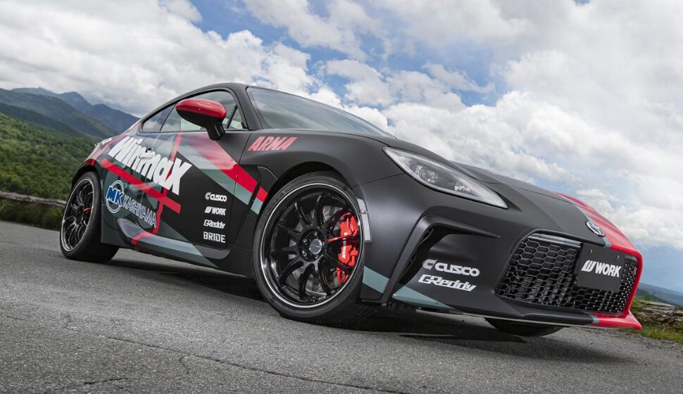 WORK EMOTION ZR10ホイールを装着し、スポーティーなデカールでカスタムされた黒色のトヨタ GR86(ZN8)。WORKホイールと大径ブレーキがレーシーな足元を演出。