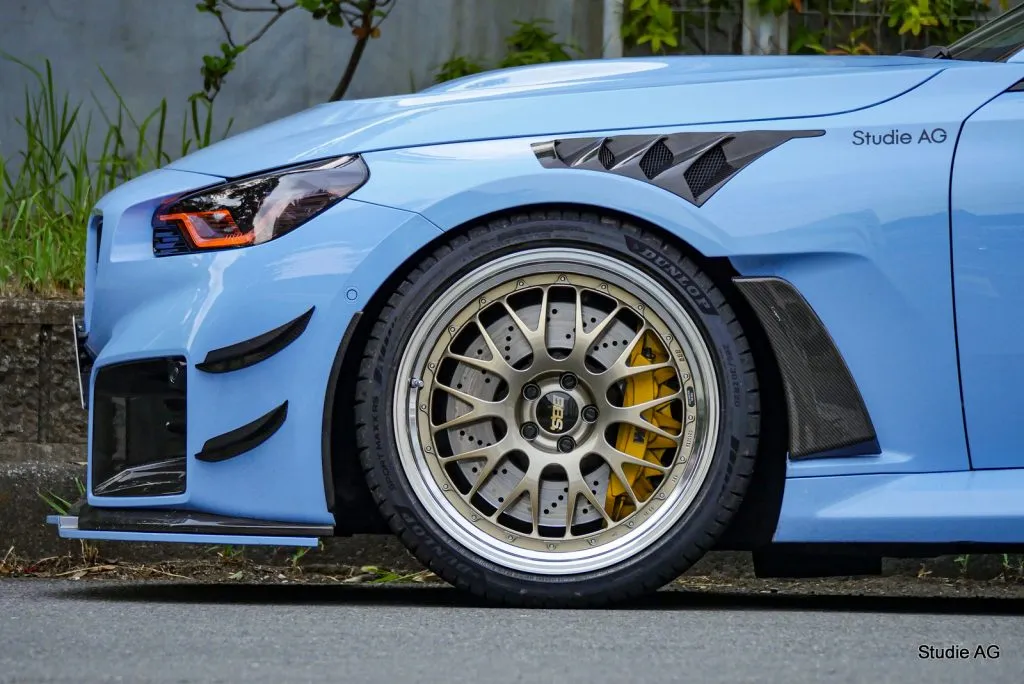 ライトブルーのBMW M2（G87）のフロントに装着されたゴールド系BBS RT88とブレーキ周辺