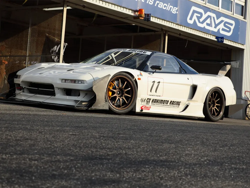 RAYSのピット前に停車した白いホンダNSXの競技車両。ゼッケン11とブロンズホイールが見える