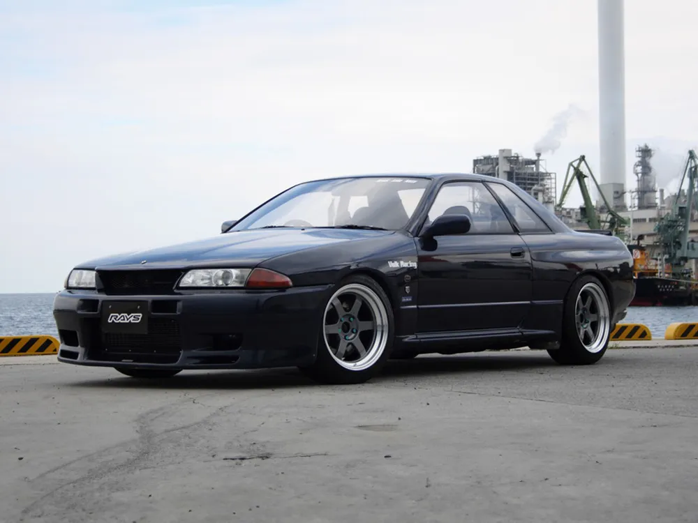 黒い日産スカイラインR32型クーペに深リムの6本スポークホイールを装着したフロント斜めからの写真